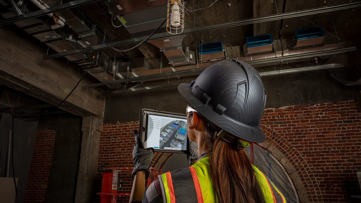 Construction worker using Autodesk software on a tablet.