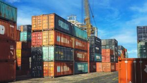 a stack of shipping containers - tariffs in construction